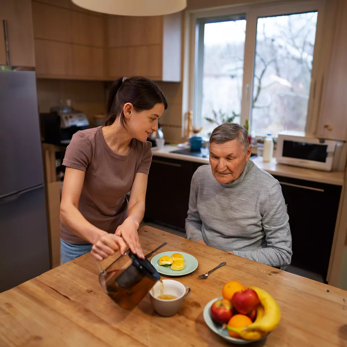 caretaker pouring coffee and making breakfast for her client